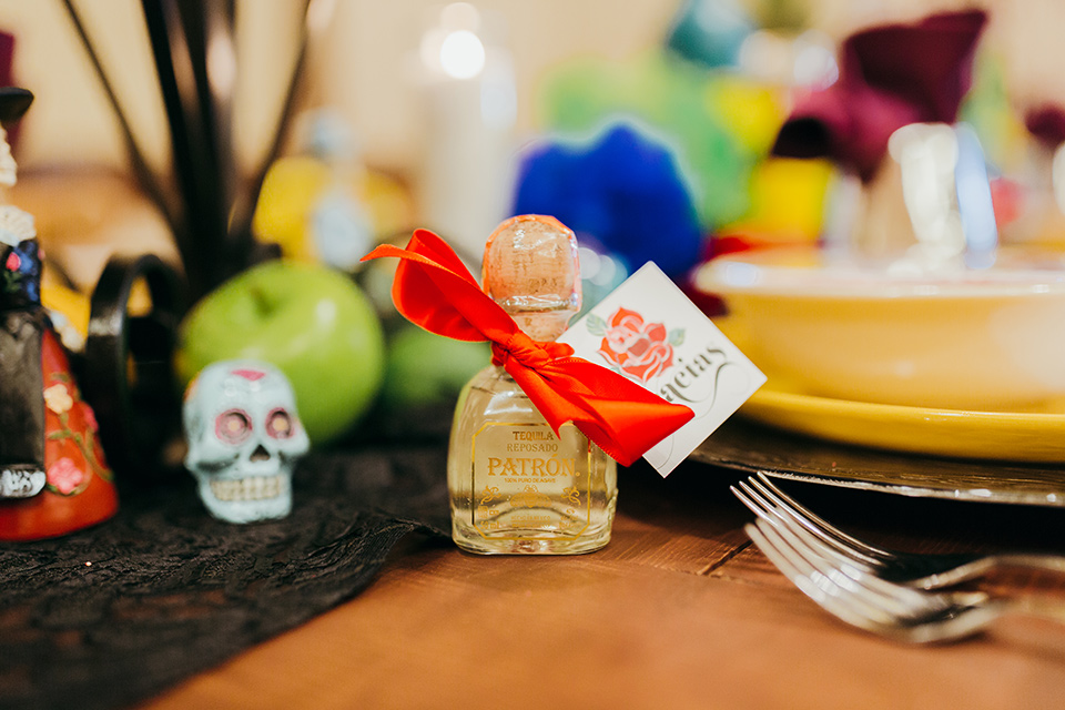 dia-de-los-muertos-shoot-table-decore-close-up-on-little-bottles-table-decor-close-up-on-candles-yellow-plates-with-sugar-skull-details-color-décor-and-silverware