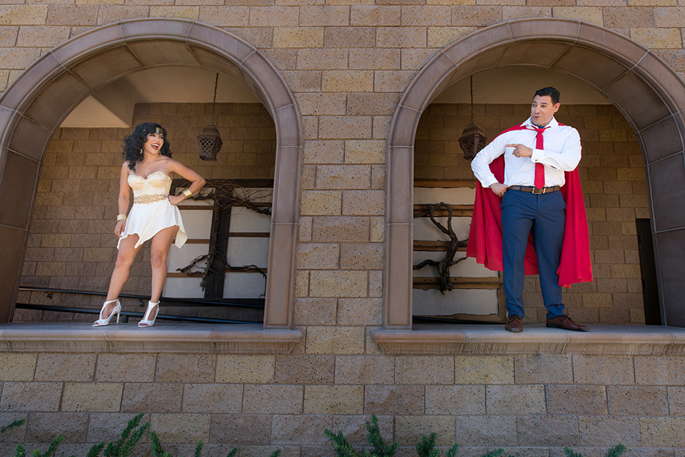 wonder-woman-meets-superman-bride-and-groom-in-costume-bride-in-a-white-silk-short-dress-with-her-wonder-woman-head-piece-while-groom-is-in-a-white-dress-shirt-with-a-red-tie-and-red-cape-and-blue-pants
