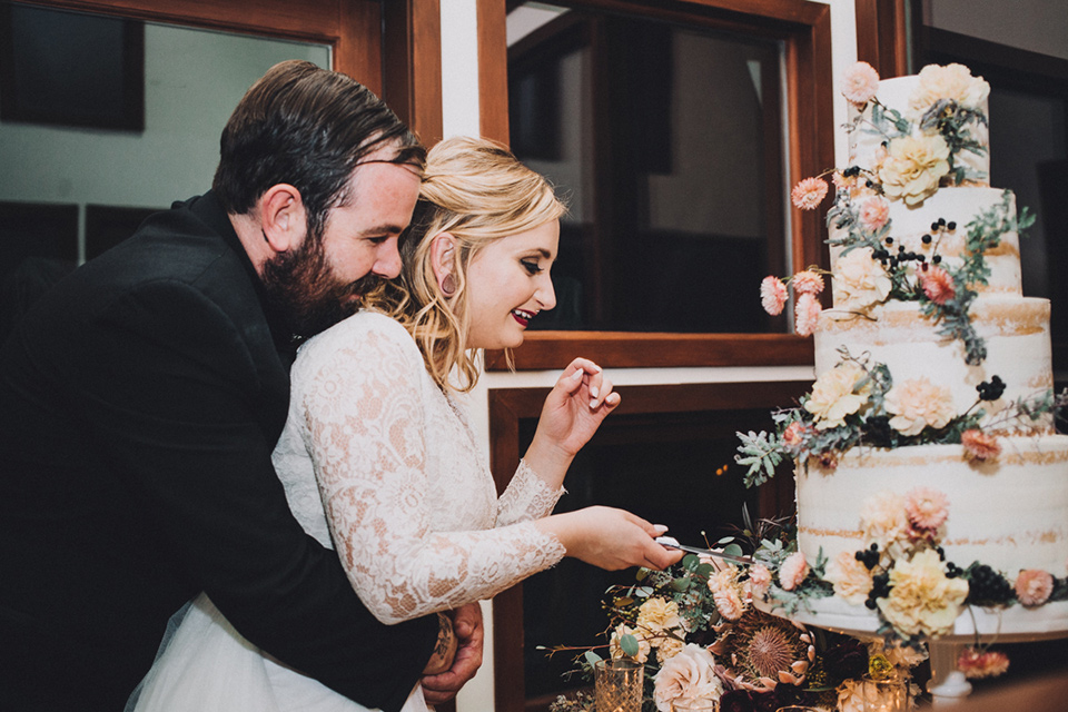 amanda-and-codys-wedding-at-the-1909-cake-cutting-bride-in-an-a-line-dress-with-a-tulle-skirt-and-lace-long-sleeve-bodice-groom-in-all-black-shawl-lapel-tuxedo