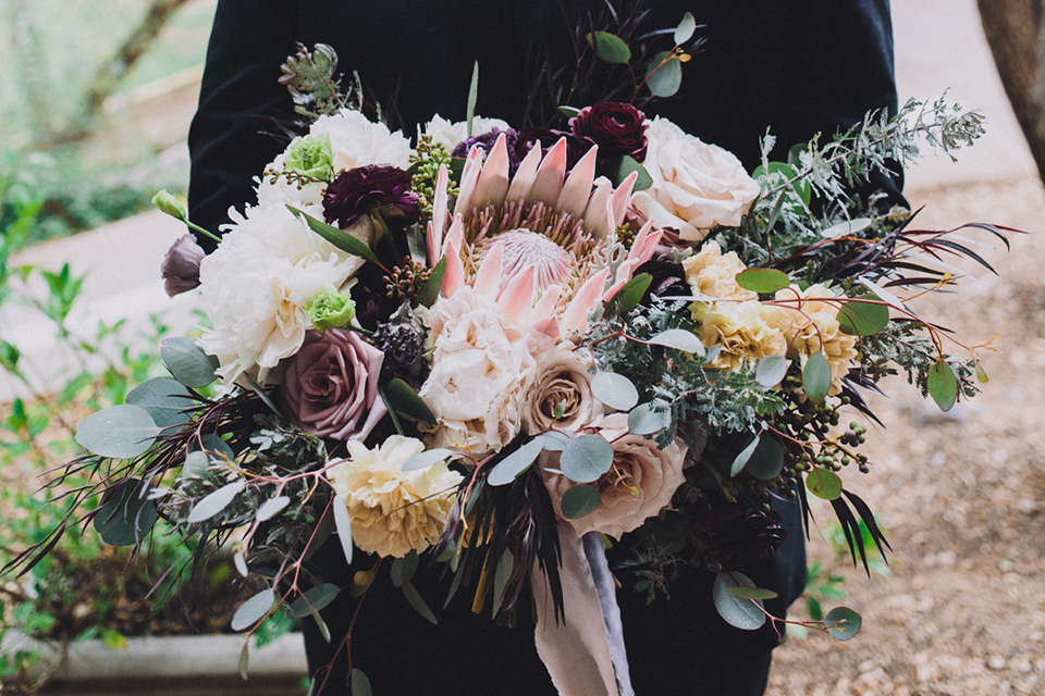 amanda-and-codys-wedding-at-the-1909-close-up-on-florals-groom-in-all-black-shawl-lapel-tuxedo