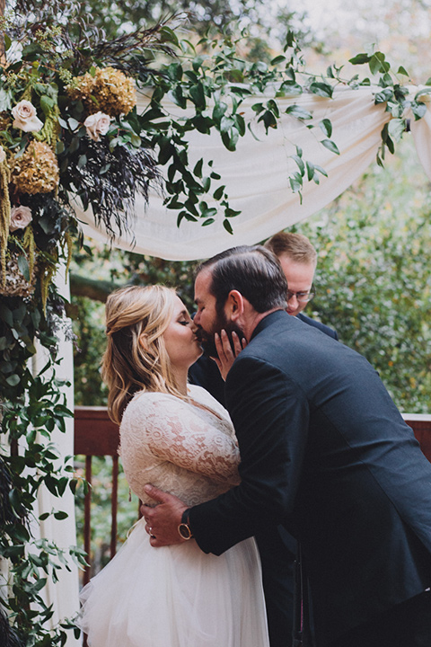 amanda-and-codys-wedding-at-the-1909-i-do-moment-bride-in-an-a-line-dress-with-a-tulle-skirt-and-lace-long-sleeve-bodice-groom-in-all-black-shawl-lapel-tuxedo