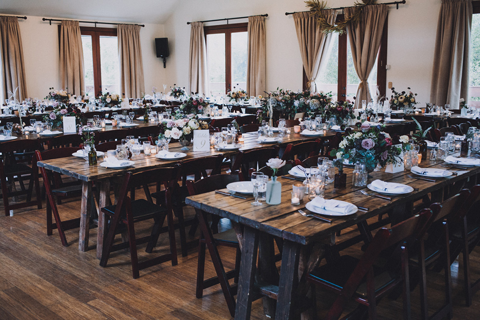 amanda-and-codys-wedding-at-the-1909-reception-set-up-rustic-deep-brown-wooden-tables-with-minimal-florals-and-simple-decor