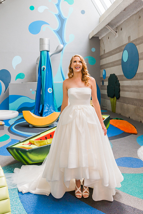 Childrens-museum-shoot-bride-looking-up-and-smilingbride-hand-on-hip-bride-wearing-a-strapless-modern-ball-gown