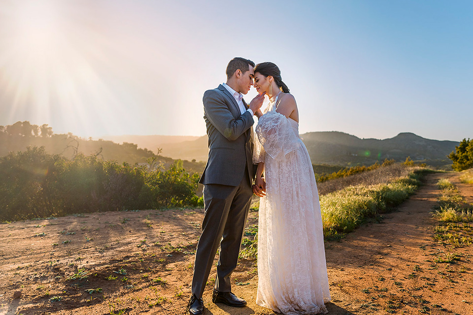 Emerald-peak-shoot-bride-and-groom-full-length-heads-touching-bride-in-a-bohemian-style-lace-dress-off-the-shoulder-groom-in-a-charcoal-grey-suit-with-a-tan-vest