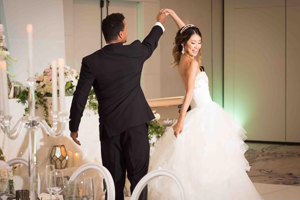 Classic glamour wedding shoot at the avenue of the arts hotel bride strapless ball gown with beaded detail on top with sweetheart neckline and groom black tuxedo with white dress shirt and long silver tie with matching vest and pocket square dancing