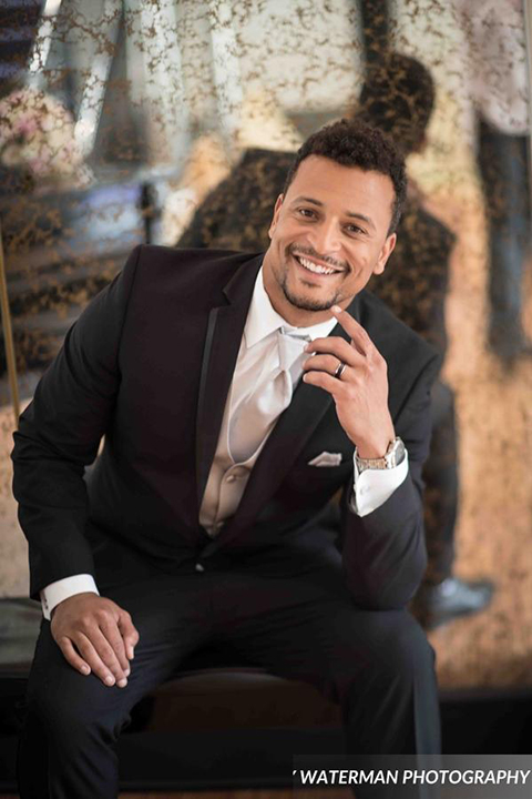 Classic glamour wedding shoot at the avenue of the arts hotel groom black tuxedo with white dress shirt and long silver tie with matching vest and pocket square smiling