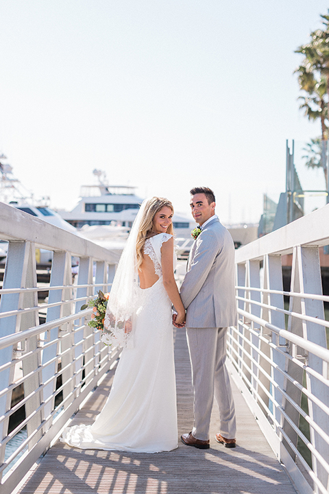 Balboa Bay Resort Wedding Bride and Groom on Dock by Water Looking Back Grey Suit