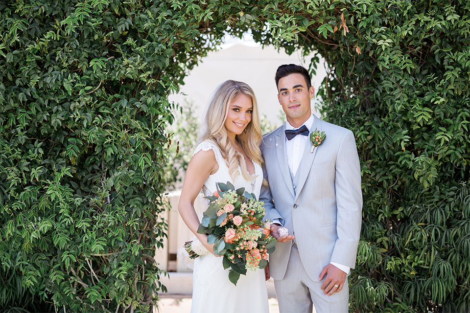 Balboa Bay Resort Wedding Bride and Groom Standing Bride Holding Flowers Grey Suit Navy Bow Tie Brown Shoes