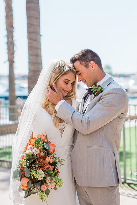 Balboa Bay Resort Wedding Bride and Groom Standing Smiling Grey Suit Navy Bow Tie Brown Shoes