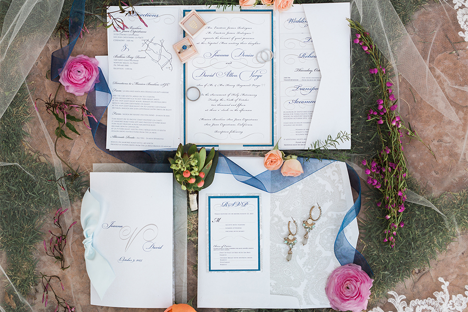 Orange county outdoor wedding shoot at balboa bay resort wedding invitations white invitations with blue and orange writing with blue ribbon decor with pink flowers and light brown background wedding photo idea for invitations