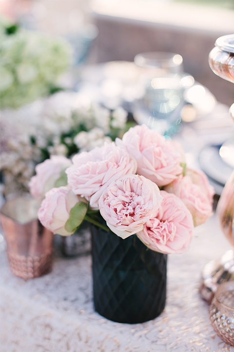 Orange county outdoor wedding shoot at old ranch country club table set up light silver table linen with white and grey place settings with navy blue napkin linen decor with clear wine glasses and dark blue designed glasses with light pink flower centerpiece decor with candles