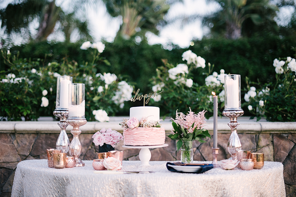 Orange county outdoor wedding shoot at old ranch country club wedding cake and dessert table two tier white and pink wedding cake with calligraphy cake topper and tall white candles with smaller candles and pink flower decor on white table linen