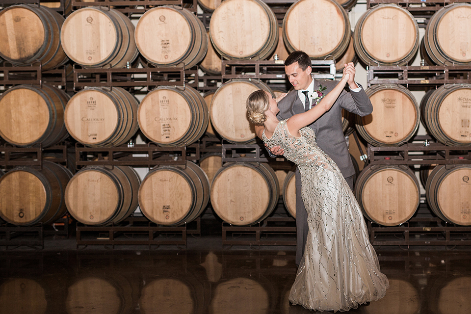 Temecula outdoor wedding at callaway winery bride form fitting lace gown with crystal beading and lace detail with open back design and beaded straps with groom grey notch lapel suit with matching vest and white dress shirt with long black skinny tie and pink floral boutonniere dancing