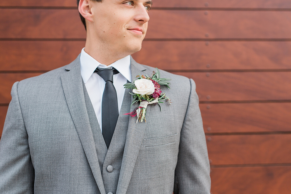 Temecula outdoor wedding at callaway winery groom grey notch lapel suit with matching vest and white dress shirt with long black skinny tie and white and pink floral boutonniere