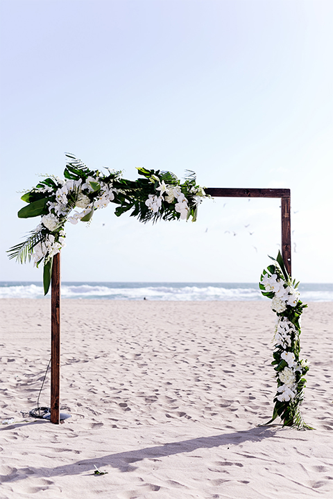 Huntington beach wedding at the hilton waterfront resort wedding ceremony altar with brown wood and white and green flower decor on sand wedding photo idea for ceremony altar