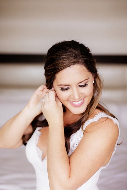 Huntington beach wedding at the hilton waterfront resort bride form fitting lace gown with a plunging neckline and thin straps with lace detail and low back design 