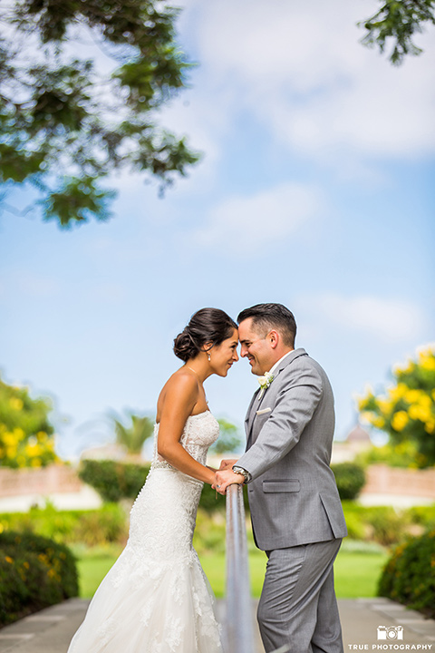 skybox-venue-wedding-bride-and-groom-touching-heads-bride-in-strapless-gown-with-beaded-bodice-groom-in-light-grey-suit-with-ivory-tie