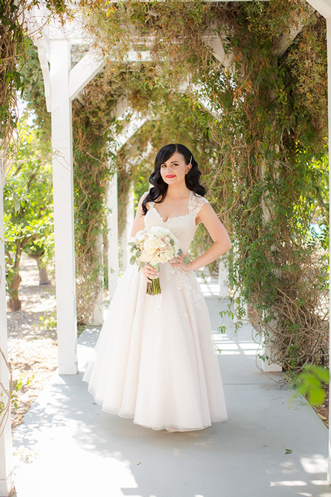 Orange county outdoor summer wedding at the heritage museum bride ball gown with lace straps and a sweetheart neckline with a short tulle skirt and long veil holding white floral bridal bouquet