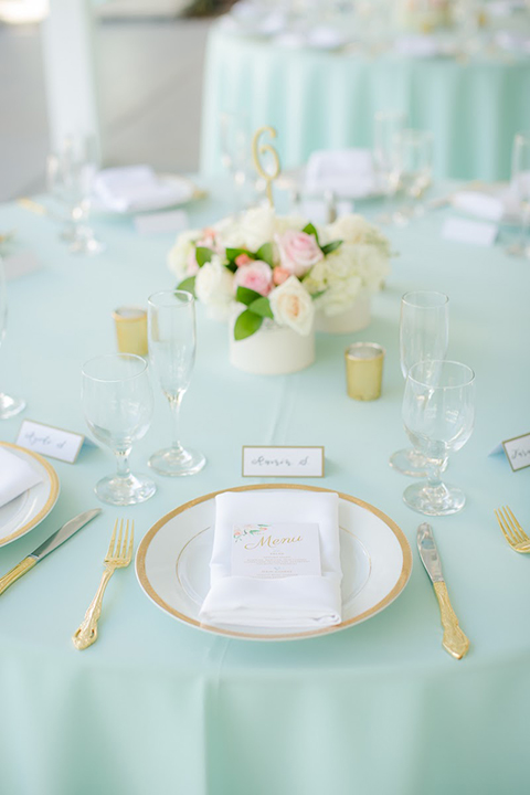 Orange county outdoor summer wedding at the heritage museum table set up with mint green table linens and white chairs with white flower centerpiece decor with glassware and white place settings with gold silverware and candles