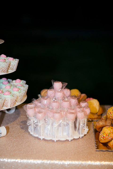 Orange county outdoor summer wedding at the heritage museum table set up with mint green table linens and white chairs with white flower centerpiece decor with glassware and white place settings with gold silverware and candles dessert table with assortment of sweets macarons cake pops and desserts