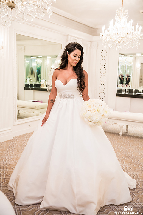 San diego glamorous wedding at the us grant hotel bride strapless ball gown with a tulle skirt and sweetheart neckline and a crystal belt with a long veil holding white floral bridal bouquet