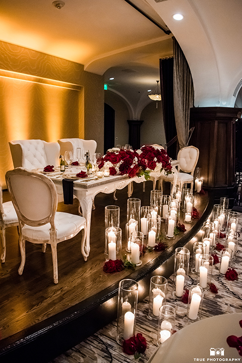 San diego glamorous wedding at the us grant hotel wedding reception decor white vintage sweetheart table and red and white flower centerpiece decor with tall white candles in glass vases on floor wedding photo idea for sweetheart table