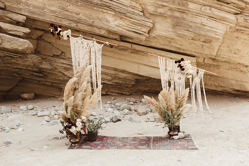 Anza-Borrego-styled-shoot-ceremony-arch-boho-style-with-crochet-drapes-and-florals-on-the-ground