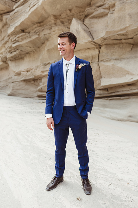 Anza-Borrego-styled-shoot-full-length-groom-attire-groom-in-colbalt-suit-with-chocolate-brown-shoes-and-bolo-tie