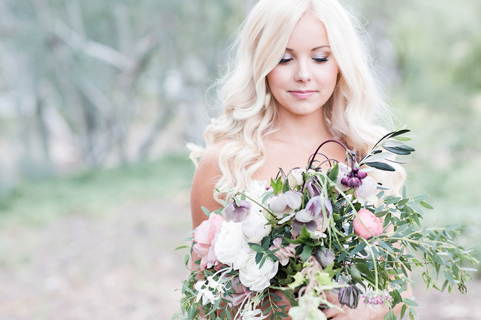 Los angeles outdoor wedding at brookview ranch bride form fitting gown with lace detail on bodice and straps with a plunging neckline holding white and pink floral bridal bouquet