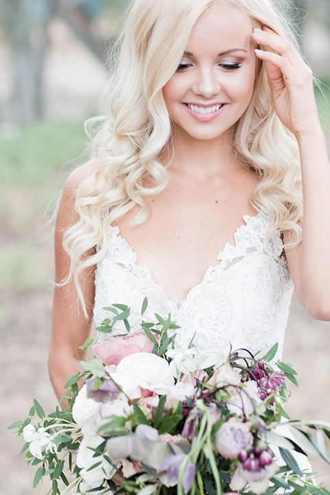 Los angeles outdoor wedding at brookview ranch bride form fitting gown with lace detail on bodice and straps with a plunging neckline holding white and pink floral bridal bouquet close up