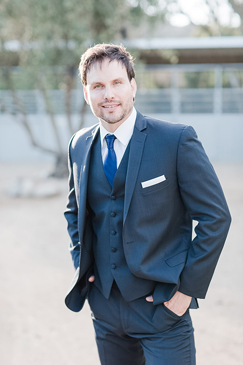 Los angeles outdoor wedding at brookview ranch groom navy blue notch lapel suit with a white dress shirt and long blue tie smiling