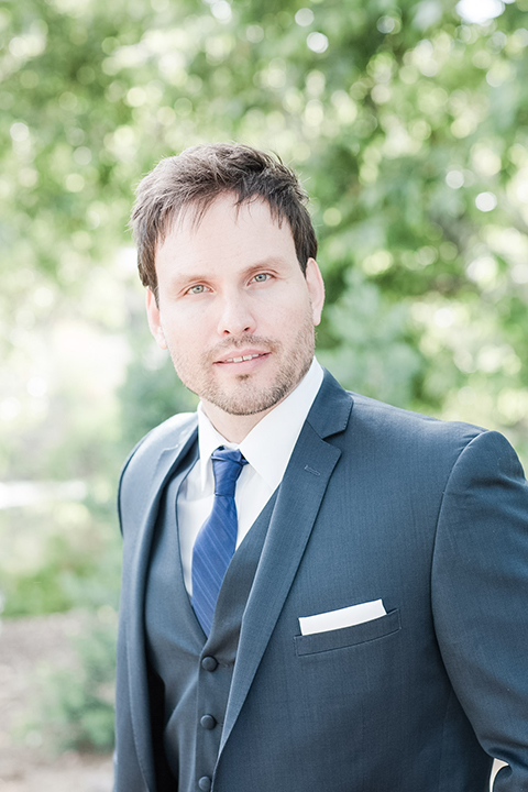 Los angeles outdoor wedding at brookview ranch groom navy blue notch lapel suit with a white dress shirt and long blue tie close up