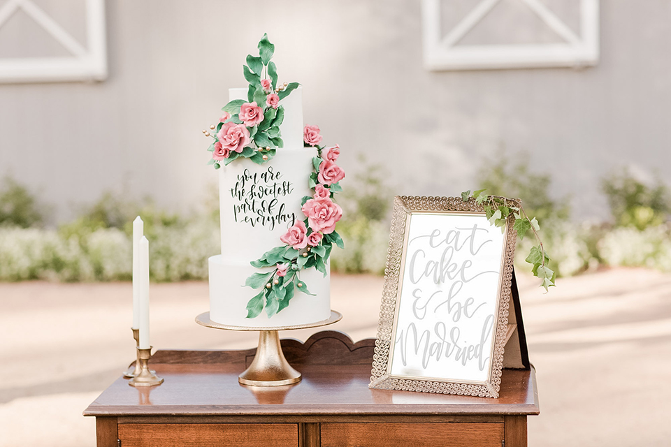 Los angeles outdoor wedding at brookview ranch table set up brown wood table with blush pink napkin decor with white place settings and tall white candles with white vintage chairs and white and pink flower decor