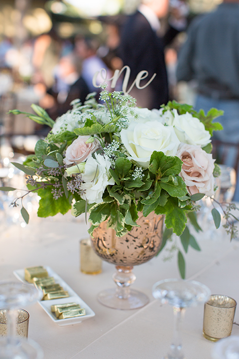 Orange county outdoor wedding at the oak canyon nature center table set up white table linen with white place settings and green and white flower centerpiece decor with dark brown chiavari chairs and candle decor