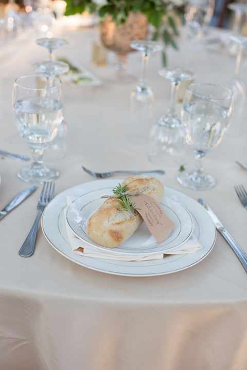 Orange county outdoor wedding at the oak canyon nature center table set up white table linen with white place settings and green and white flower centerpiece decor with dark brown chiavari chairs and candle decor