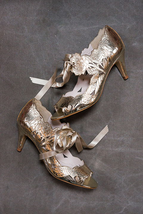 Fox and the owl wedding shoot at big daddys antiques bride metallic heels with flower designs and laying down on grey background wedding photo idea for brides shoes