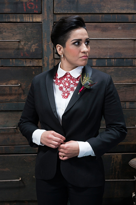 Fox and the owl wedding shot at big daddys antiques bride black womens shawl lapel tuxedo with a white dress shirt and red lace design on neckline with red floral boutonniere