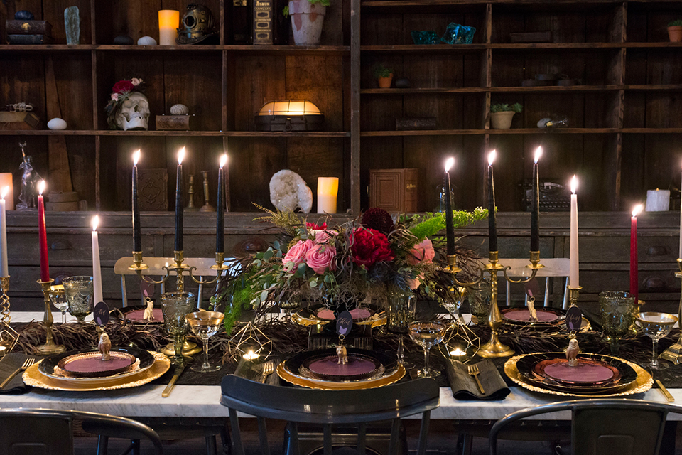 Fox and the owl wedding shoot at big daddys antiques table set up black table with white table runner and black and red place settings with tall white candles and red and pink flower centerpiece decor with tall black candles with fox and owl decor