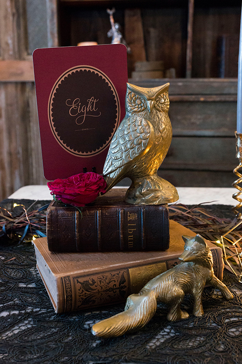 Fox and the owl wedding shoot at big daddys antiques table set up black table with white table runner and black and red place settings with tall white candles and red and pink flower centerpiece decor with tall black candles with fox and owl decor