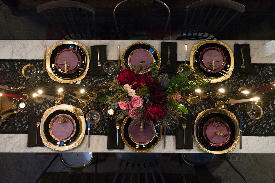 Fox and the owl wedding shoot at big daddys antiques table set up black table with white table runner and black and red place settings with tall white candles and red and pink flower centerpiece decor with tall black candles with fox and owl decor