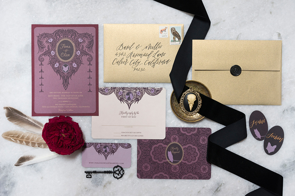 Fox and the owl wedding shoot at big daddys antiques wedding invitations purple and white invitations with dark purple ribbon and tan envelopes and red flower decor on white marble background wedding photo idea for invitations
