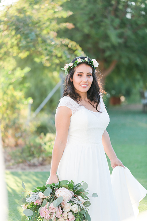 Temecula outdoor wedding at bel vino winery bride a line chiffon gown with straps and lace detail on bodice with a sweetheart neckline and white and green flower crown holding white and green floral bridal bouquet