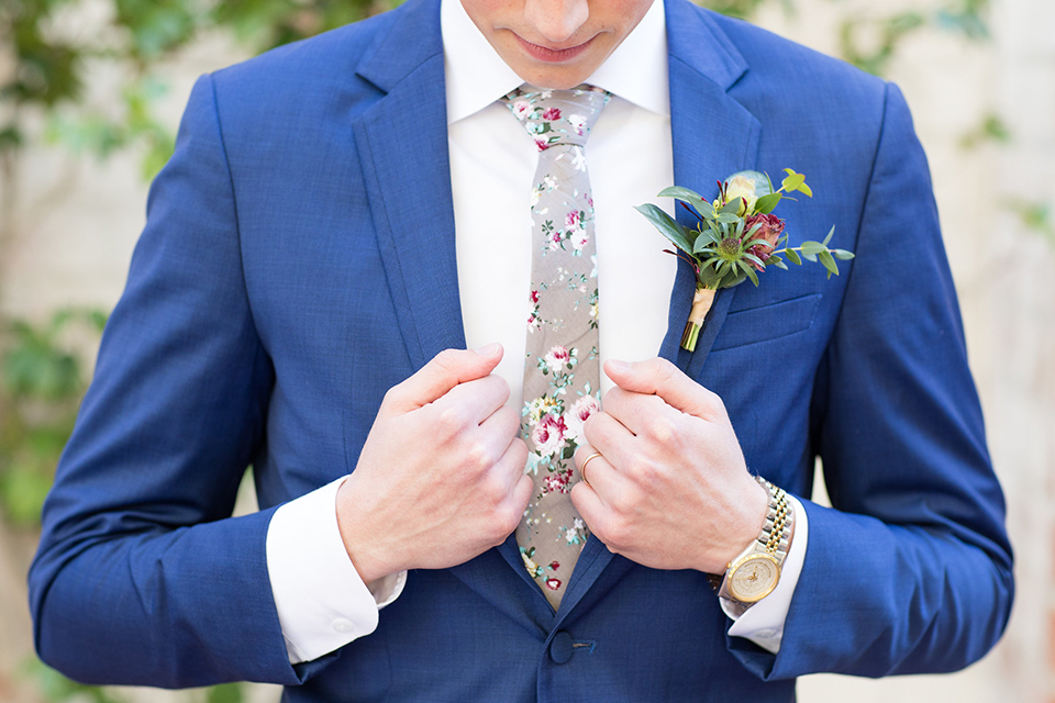 Boutonniere-style-cobalt-blue-notch-lapel-suit-with-a-grey-floral-long-tie-and-a-greenery-floral-boutonniere