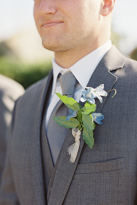 Boutonniere-style-grey-notch-lapel-suit-with-a-matching-grey-long-tie-and-light-blue-floral-boutonniere