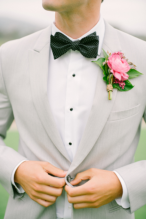 Boutonniere-style-light-grey-peak-lapel-suit-with-a-black-bow-tie-and-pink-floral-boutonniere