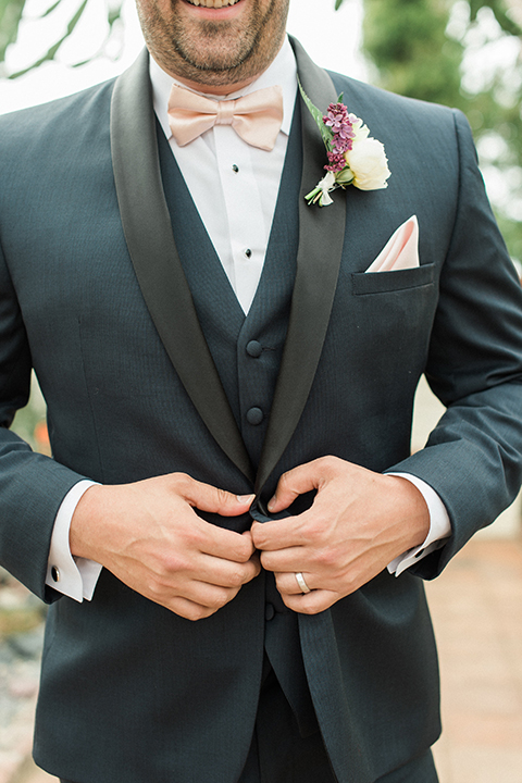 Boutonniere-style-navy-shawl-lapel-tuxedo-with-a-blush-pink-bow-tie-and-white-and-red-floral-boutonniere