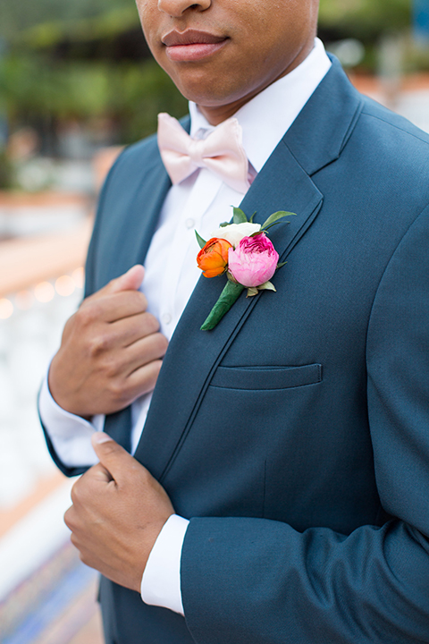 Boutonniere-style-slate-blue-notch-lapel-suit-with-a-matching-bow-tie-and-pink-floral-boutonniere