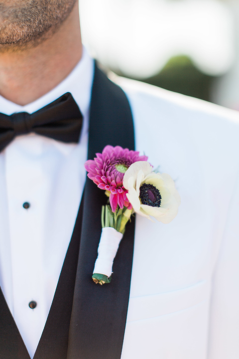 Boutonniere-style-white-shawl-lapel-tuxedo-with-a-black-bow-tie-and-white-and-pink-floral-boutonniere