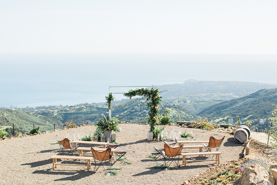 Los angeles outdoor same sex wedding at malibu solstice canyon ceremony set up with brown chairs and benches with a greenery altar and greenery florals along aisle wedding photo idea for ceremony set up