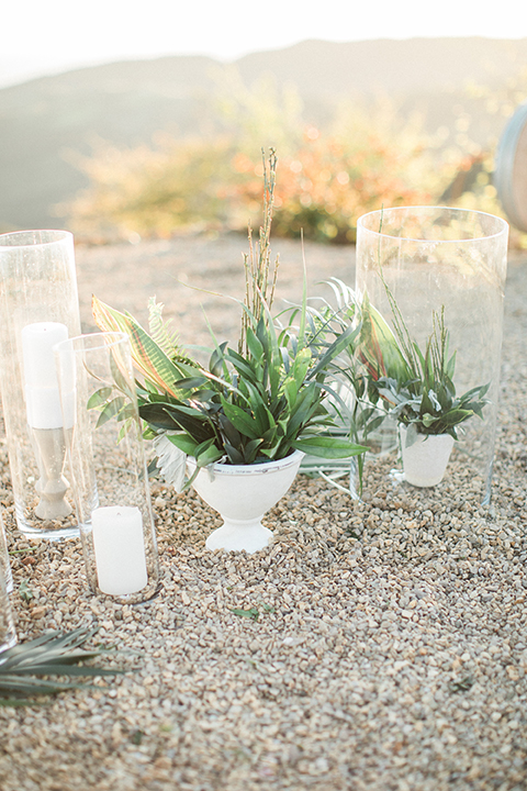 Los angeles same sex wedding at malibu solstice canyon table set up light brown wood table with white chairs and white and green flower centerpiece decor with white candles in glass vases and clear glass plates wedding photo idea